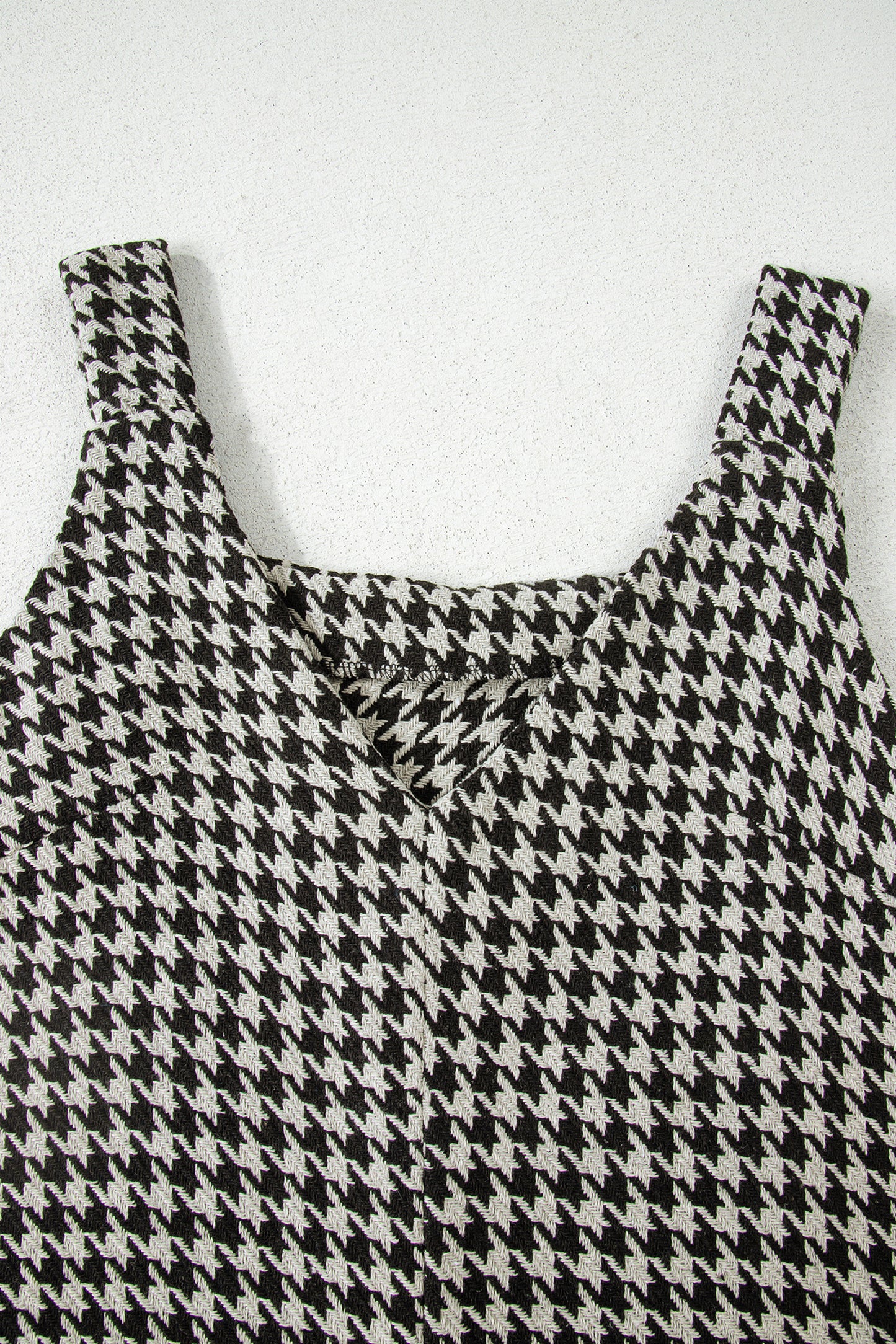 Black textured houndstooth jacquard sleeveless mini dress with V-neckline and A-line silhouette.