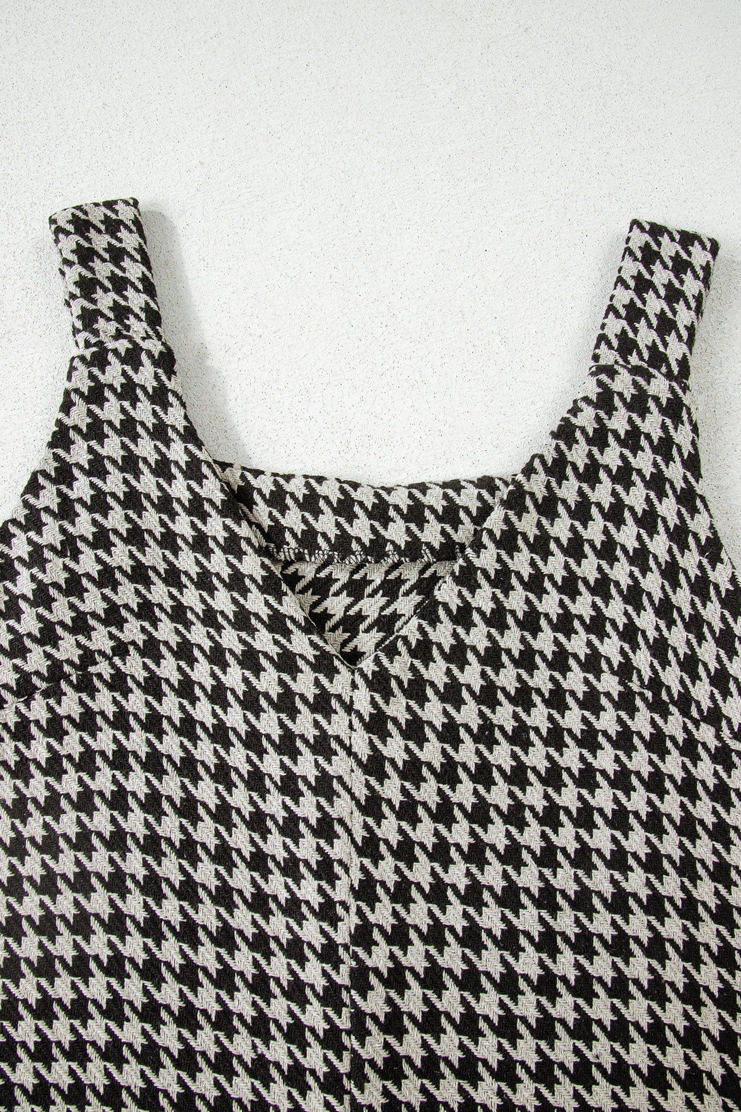 Black textured houndstooth jacquard sleeveless mini dress with V-neckline and A-line silhouette.