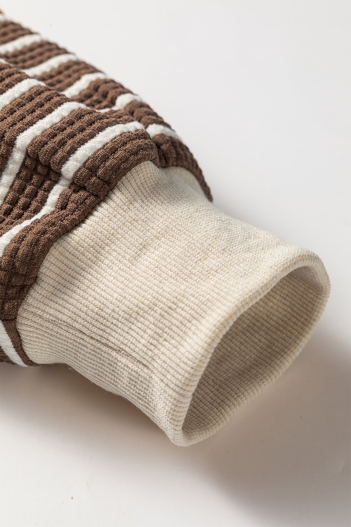 Cocoa Caramel and ivory striped colorblock pullover with a collared V-neckline, dropped shoulders, and long paneled sleeves.
