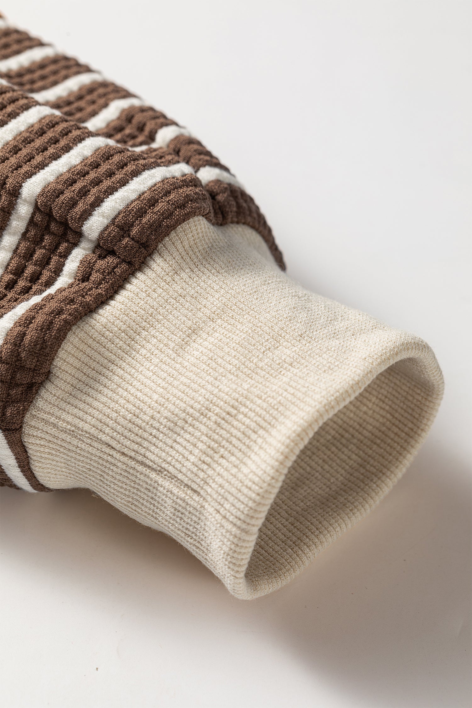 Cocoa Caramel and ivory striped colorblock pullover with a collared V-neckline, dropped shoulders, and long paneled sleeves.