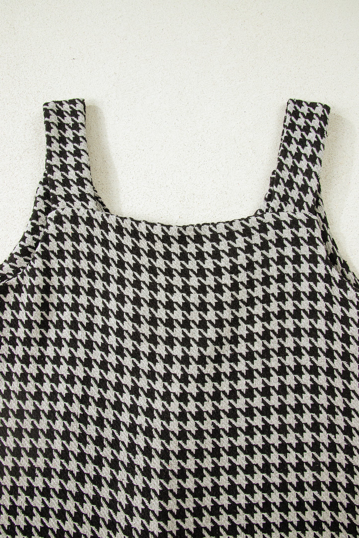 Black textured houndstooth jacquard sleeveless mini dress with V-neckline and A-line silhouette.
