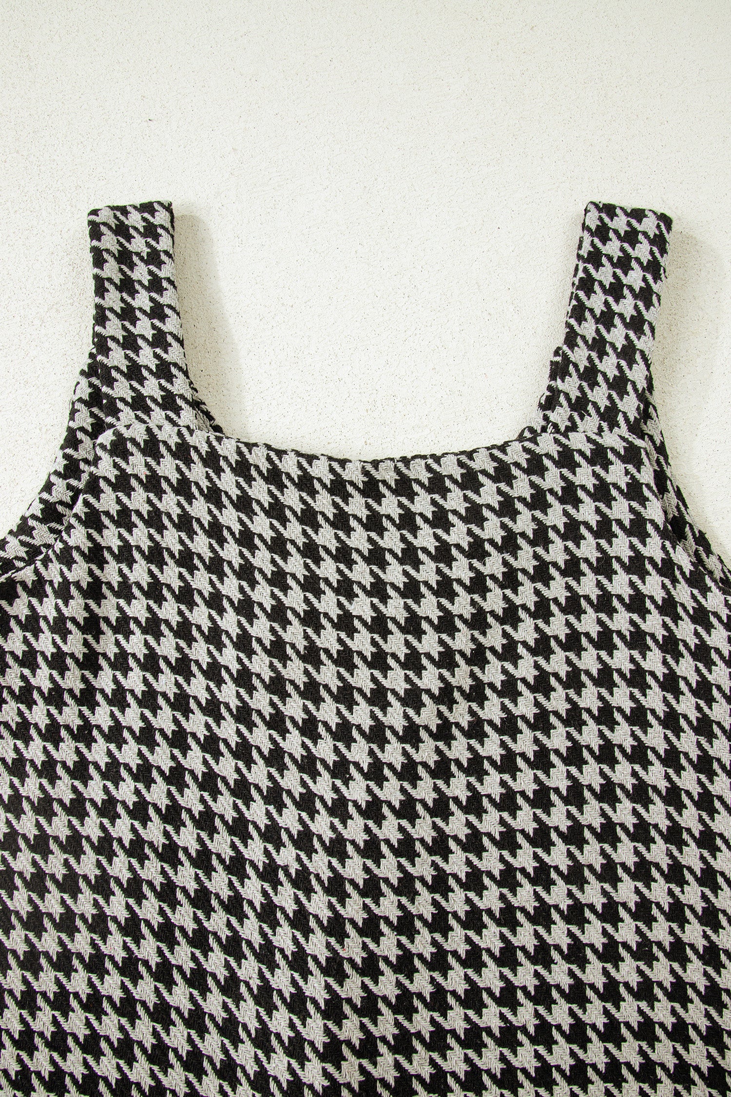 Black textured houndstooth jacquard sleeveless mini dress with V-neckline and A-line silhouette.