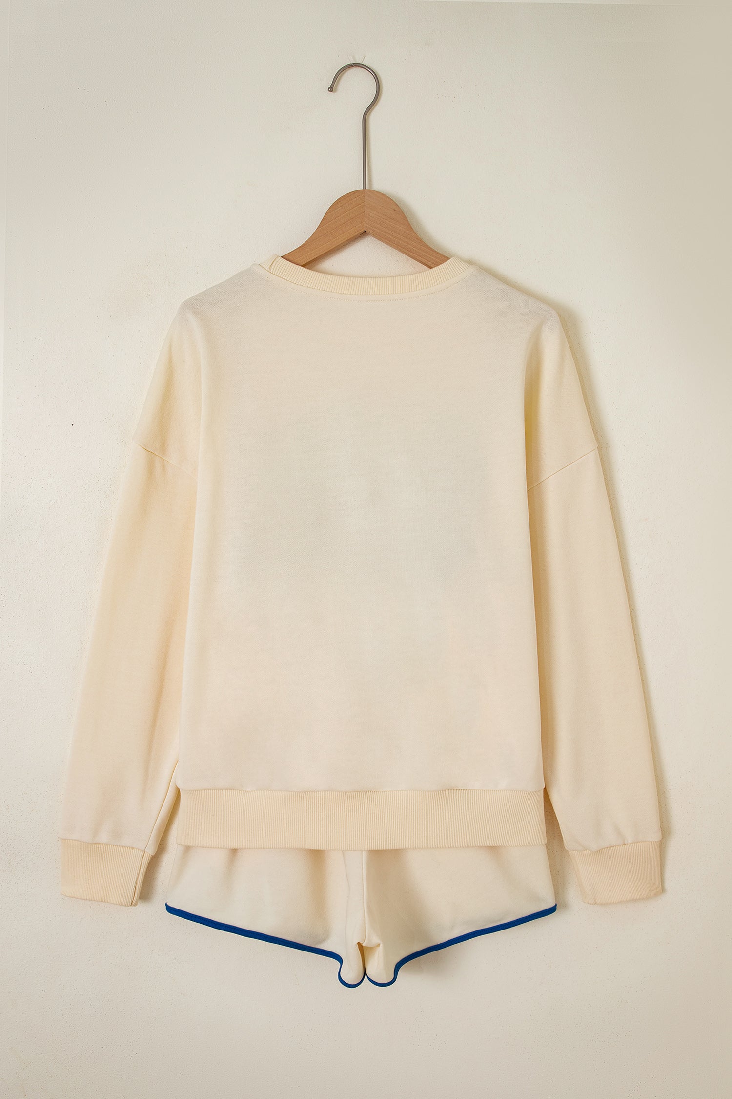 Cream Game Day embroidered sweatshirt and matching drawstring shorts set featuring long sleeves, blue contrast trim, relaxed fit, and casual sporty style.