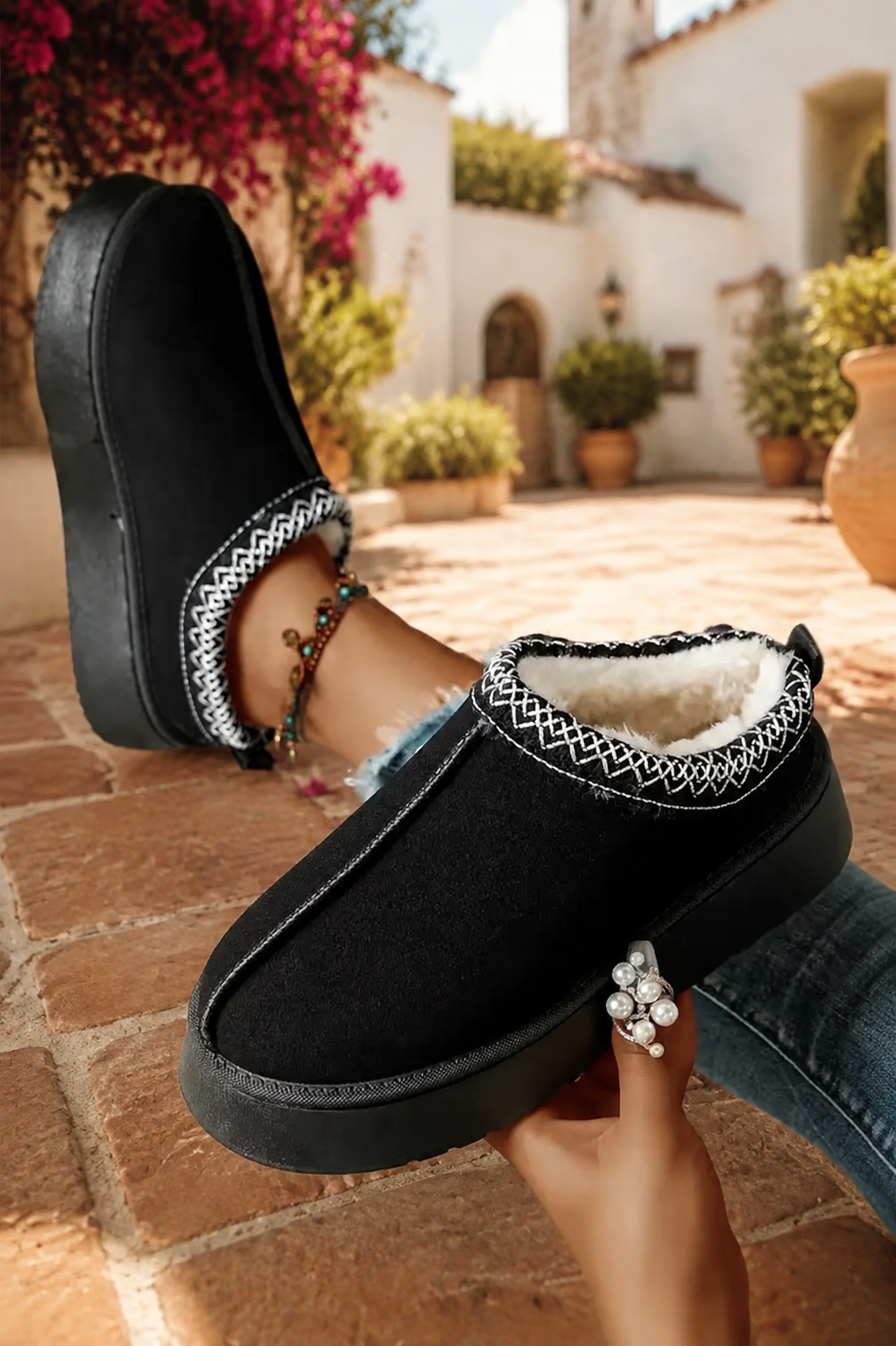 Black faux-suede platform slippers with cream plush lining, round toes, and contrasting white stitched collar trim