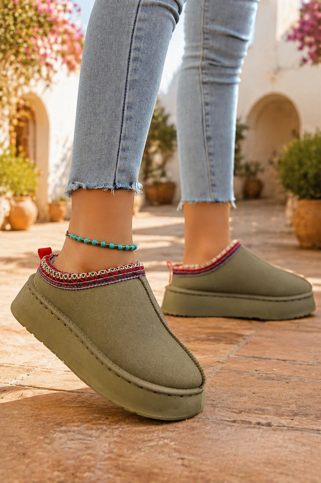 Olive green faux-suede platform slippers with plush lining, round toes, and decorative red stitched collar trim