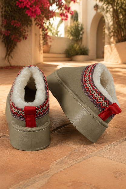 Olive green faux-suede platform slippers with plush lining, round toes, and decorative red stitched collar trim