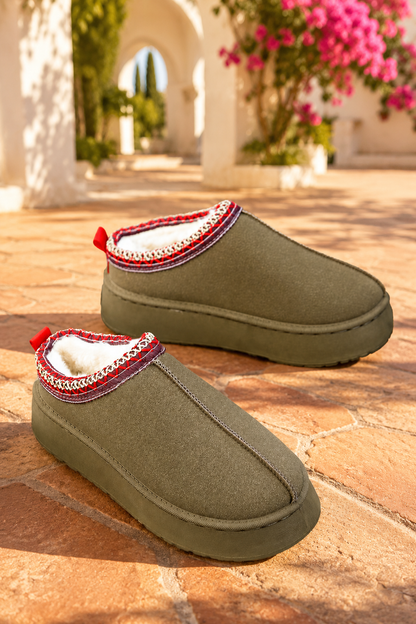 Olive green faux-suede platform slippers with plush lining, round toes, and decorative red stitched collar trim