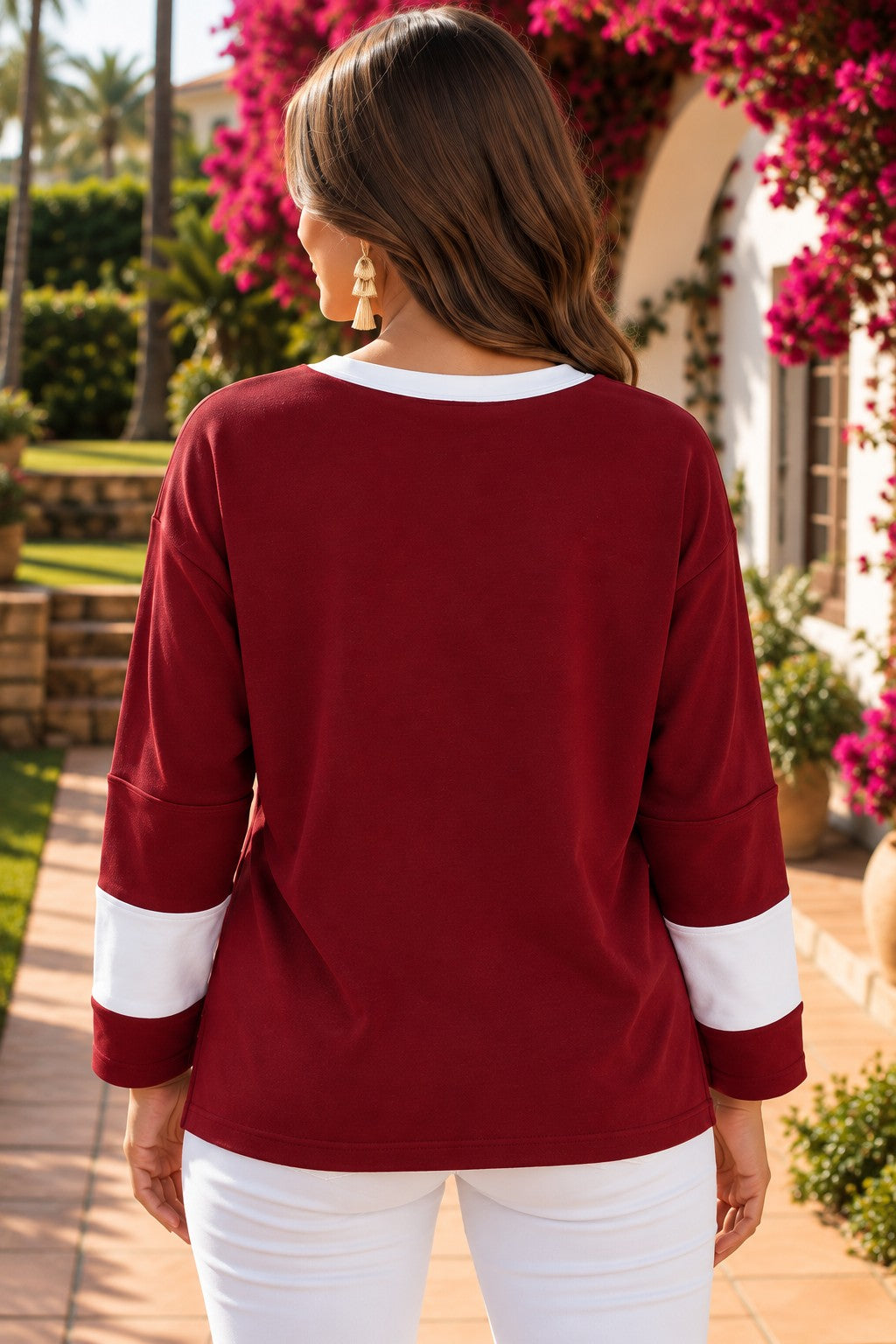 Red Dahlia women’s long sleeve top with round white contrast neckline, white sleeve bands, oversized daisy patch front, and relaxed shift silhouette.