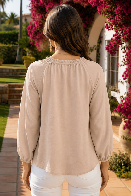 Beige textured women's blouse featuring a ruffle split neckline, relaxed silhouette, three-quarter sleeves, and gathered elastic cuffs.