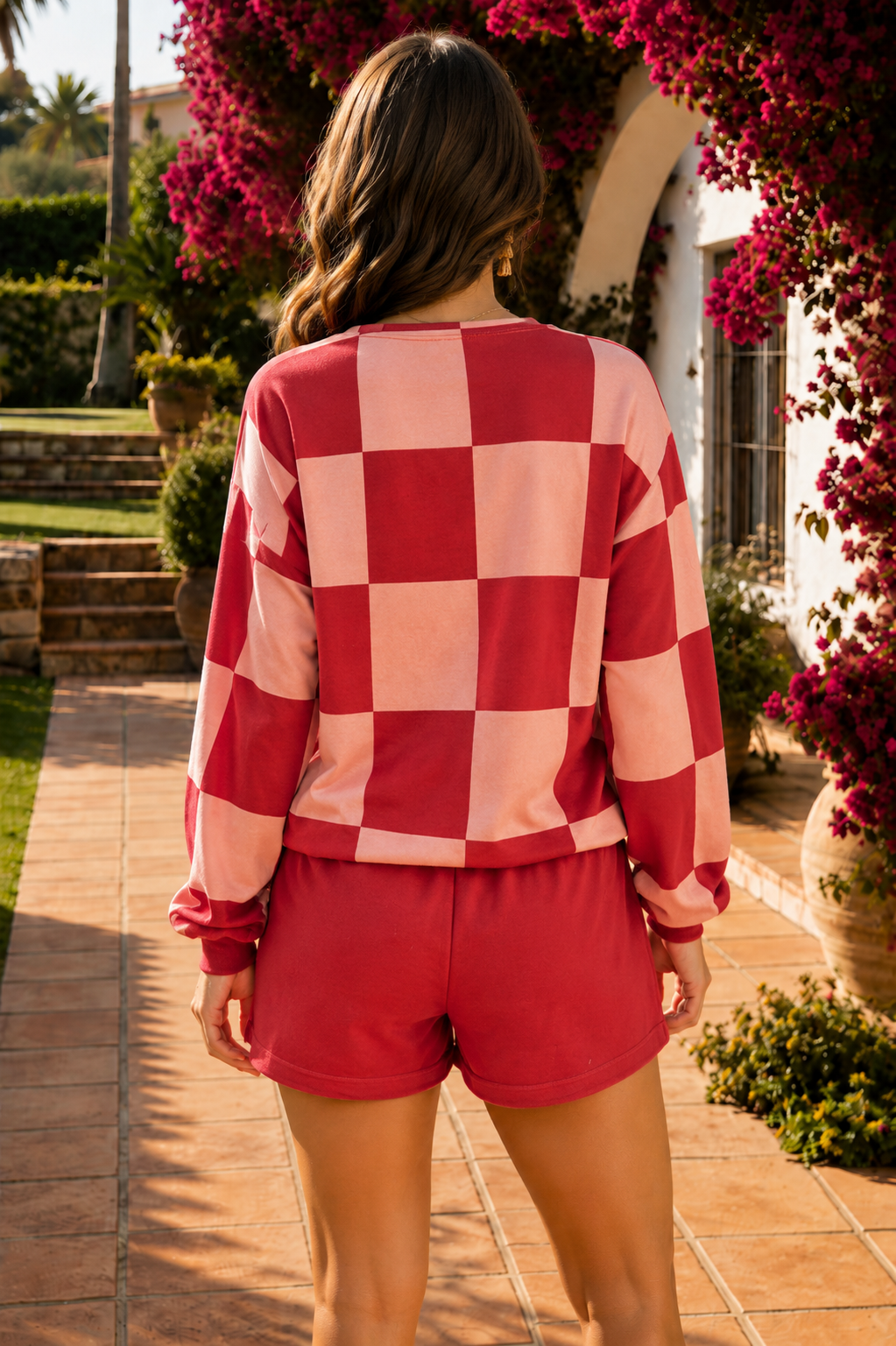 Woman wearing a red and pink checkerboard long sleeve top with red drawstring shorts