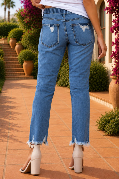 Medium wash blue distressed slim straight leg jeans with drawstring elastic waist and raw hem
