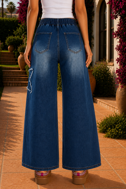 Women's medium wash denim high-waist wide-leg jeans with oversized frayed star patch appliqués, full-length relaxed fit, button fly, and functional pockets.