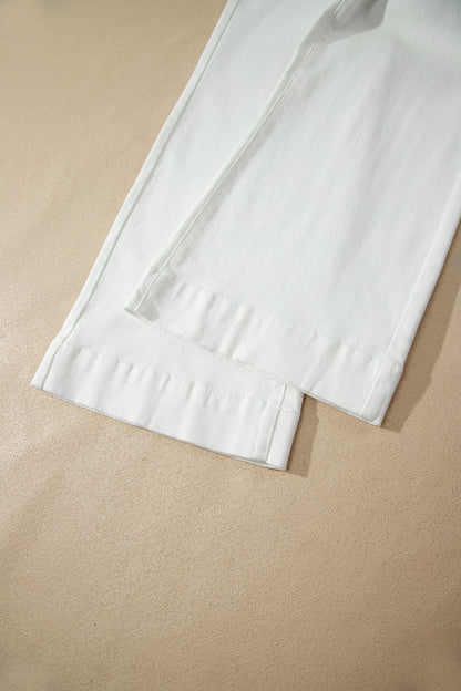 White high rise wide leg jeans with double-button waistband, front pockets and cropped hem.