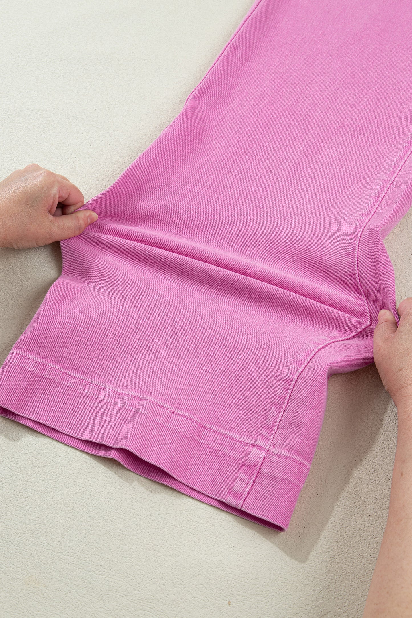 Pink high rise wide leg jeans with double-button waistband, front pockets and cropped hem.
