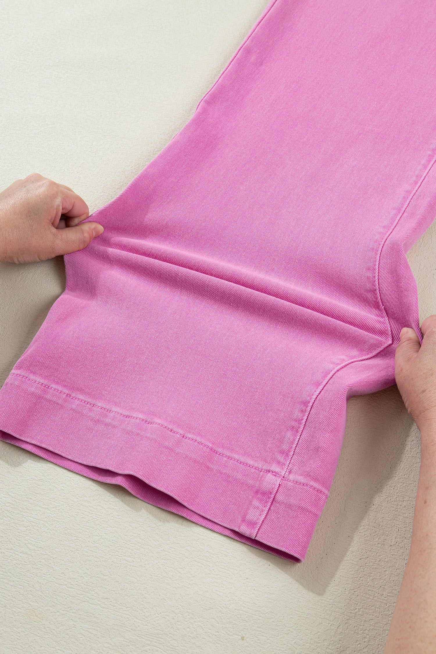 Pink high rise wide leg jeans with double-button waistband, front pockets and cropped hem.