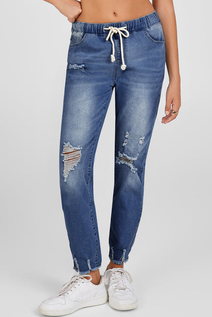 Medium wash blue distressed slim straight leg jeans with drawstring elastic waist and raw hem