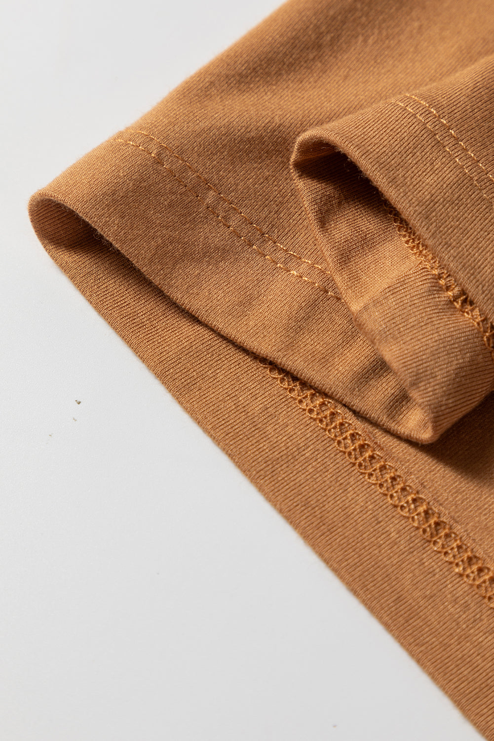 Woman wearing a Caramel Mocha scoop neck long sleeve top with a soft casual fit and white pants.