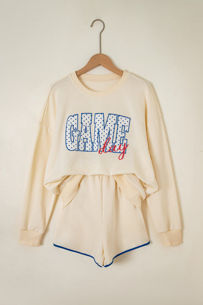 Cream Game Day embroidered sweatshirt and matching drawstring shorts set featuring long sleeves, blue contrast trim, relaxed fit, and casual sporty style.