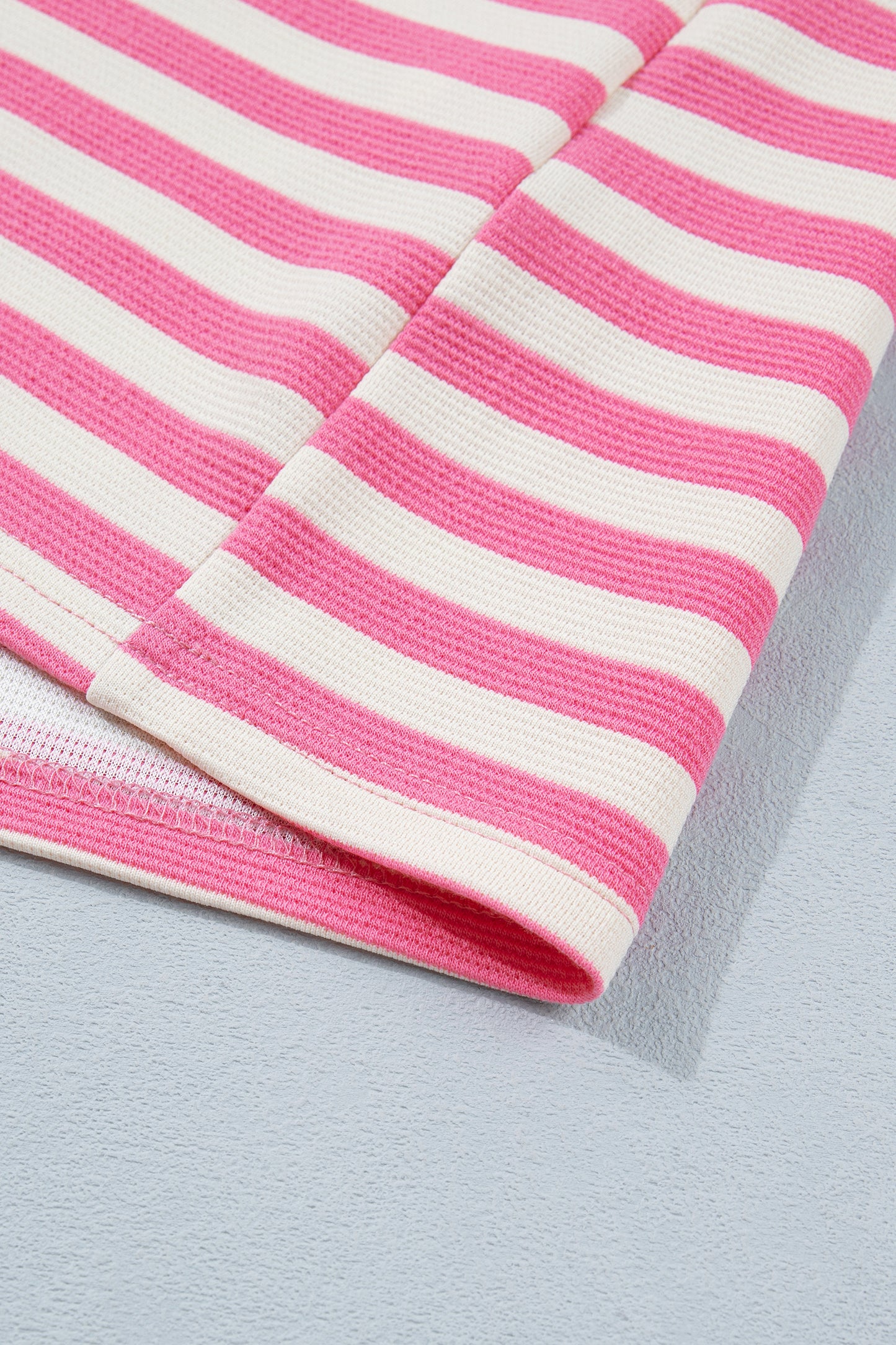 Pink and white textured striped knit short sleeve top with blue contrast ribbed neckline and sleeve cuffs, relaxed fit, and crew neckline.