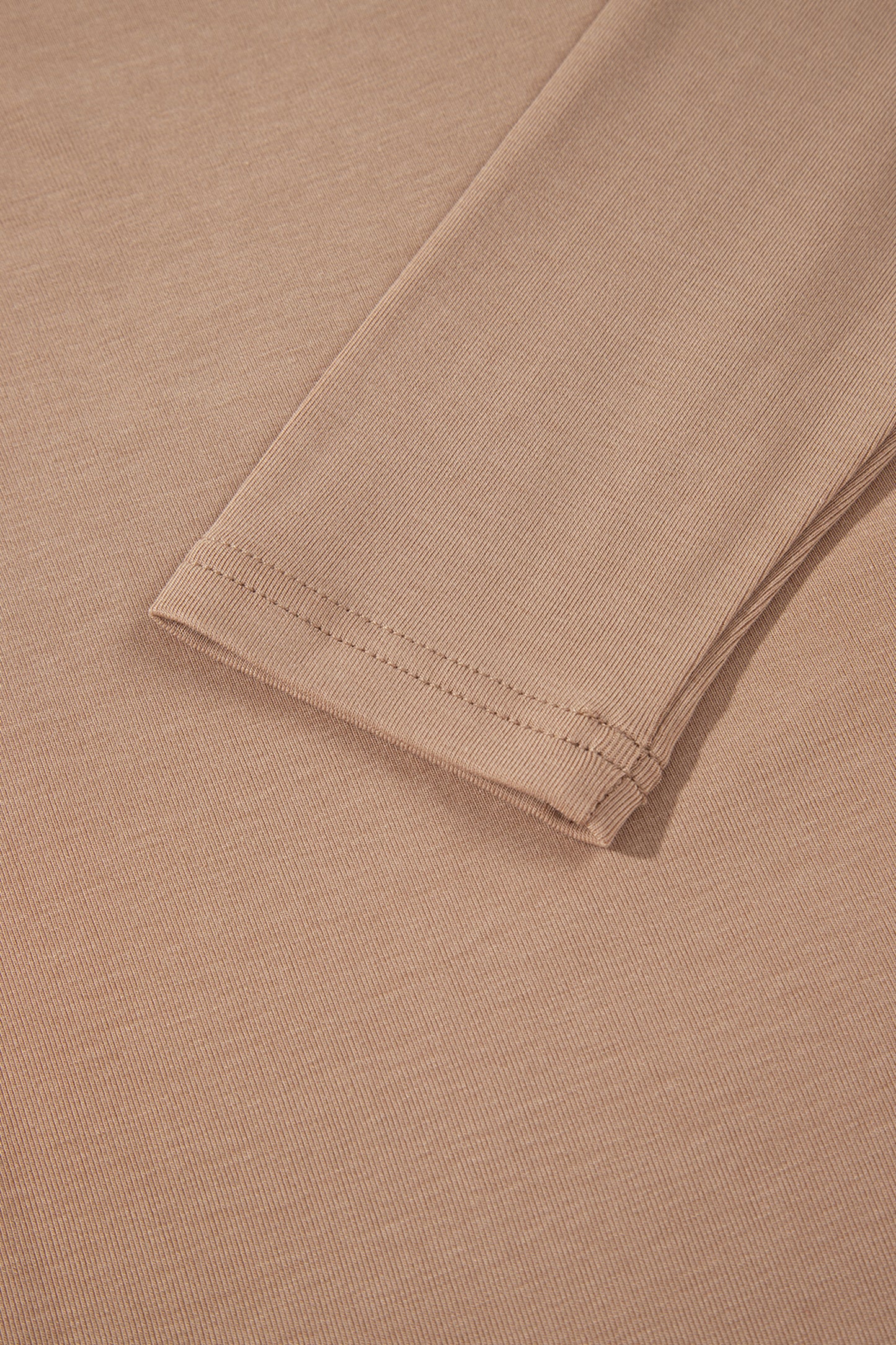 Warm taupe fitted high neck long sleeve top with a smooth stretch-knit finish and regular-length hem.