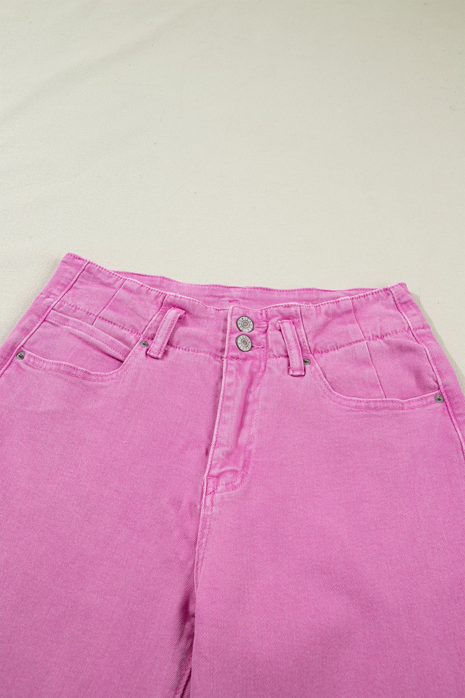 Pink high rise wide leg jeans with double-button waistband, front pockets and cropped hem.