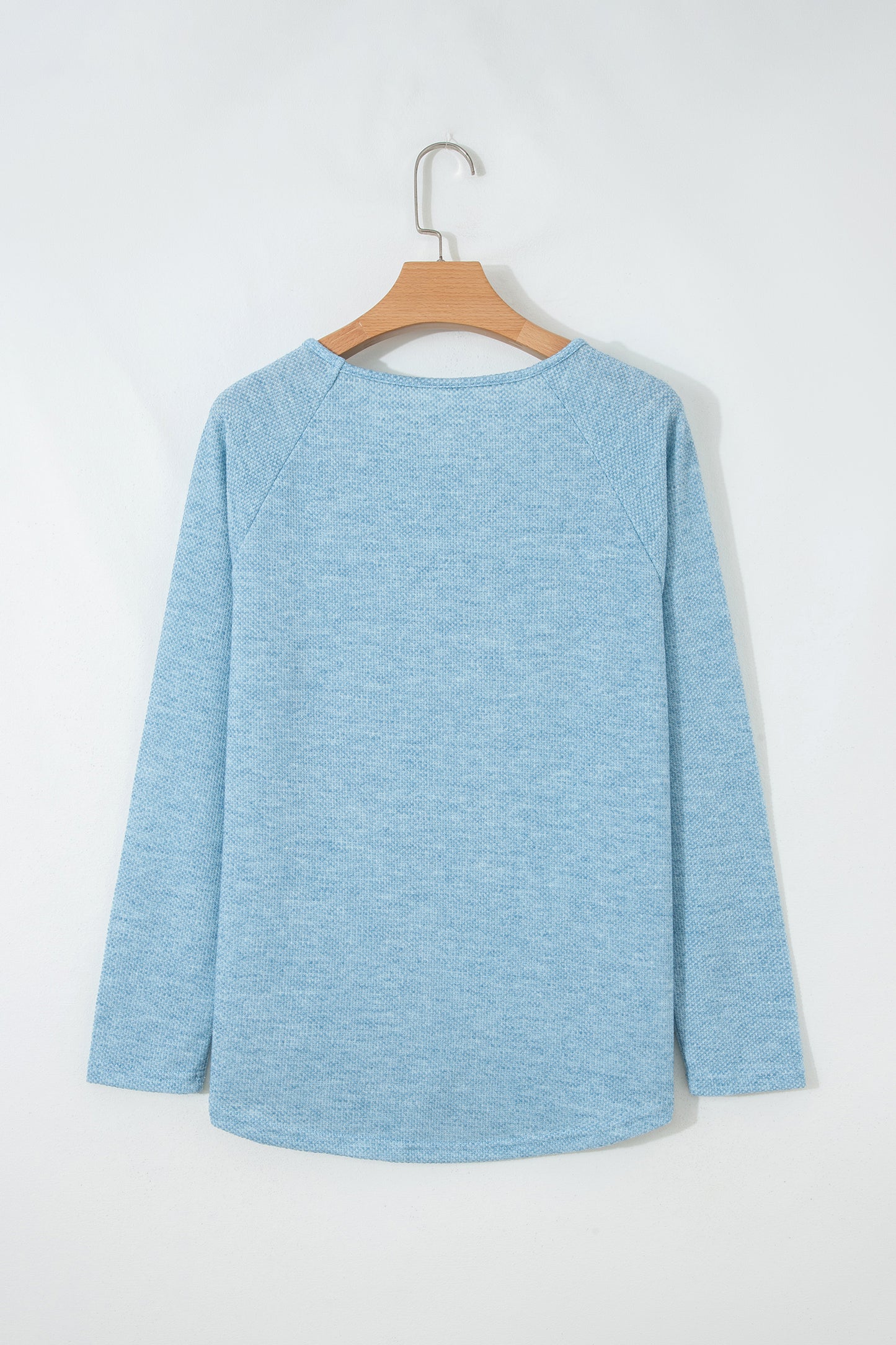 Powder Blue textured raglan long sleeve top with round neckline, relaxed fit, and curved hem
