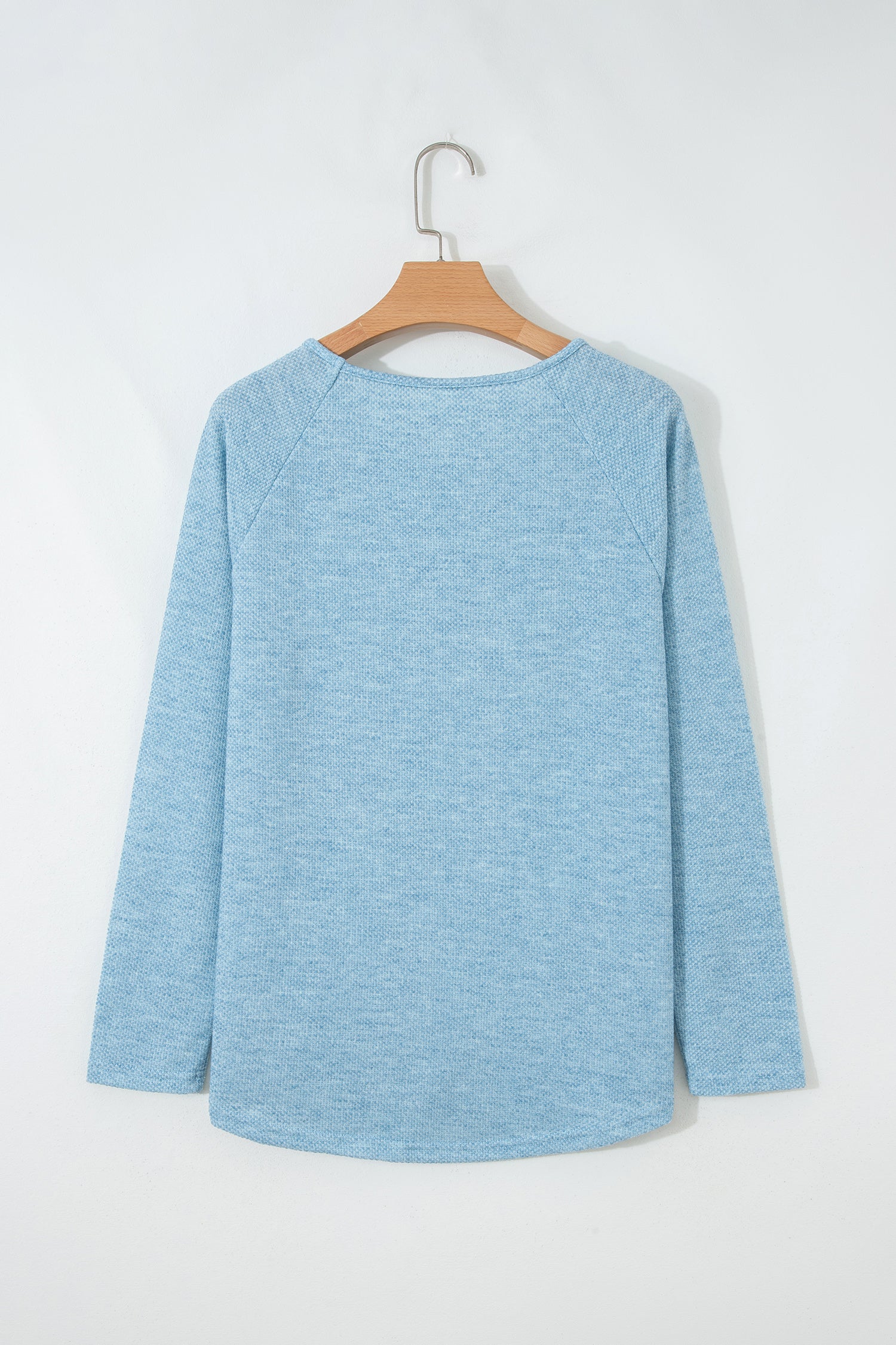 Powder Blue textured raglan long sleeve top with round neckline, relaxed fit, and curved hem