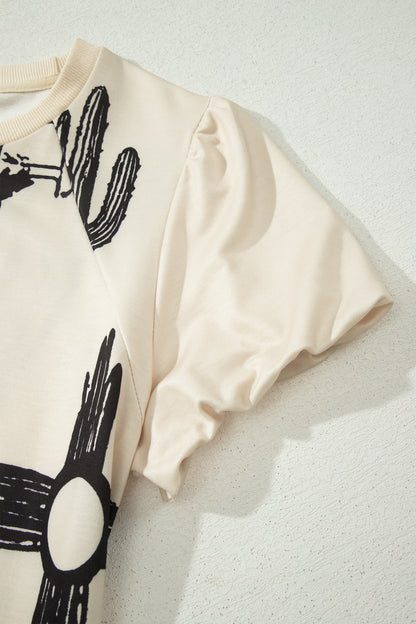 Cream Western graphic print top with crew neckline, short sleeves with gathered armholes, and black cowboy boot, cactus, horseshoe, and Southwestern motifs.