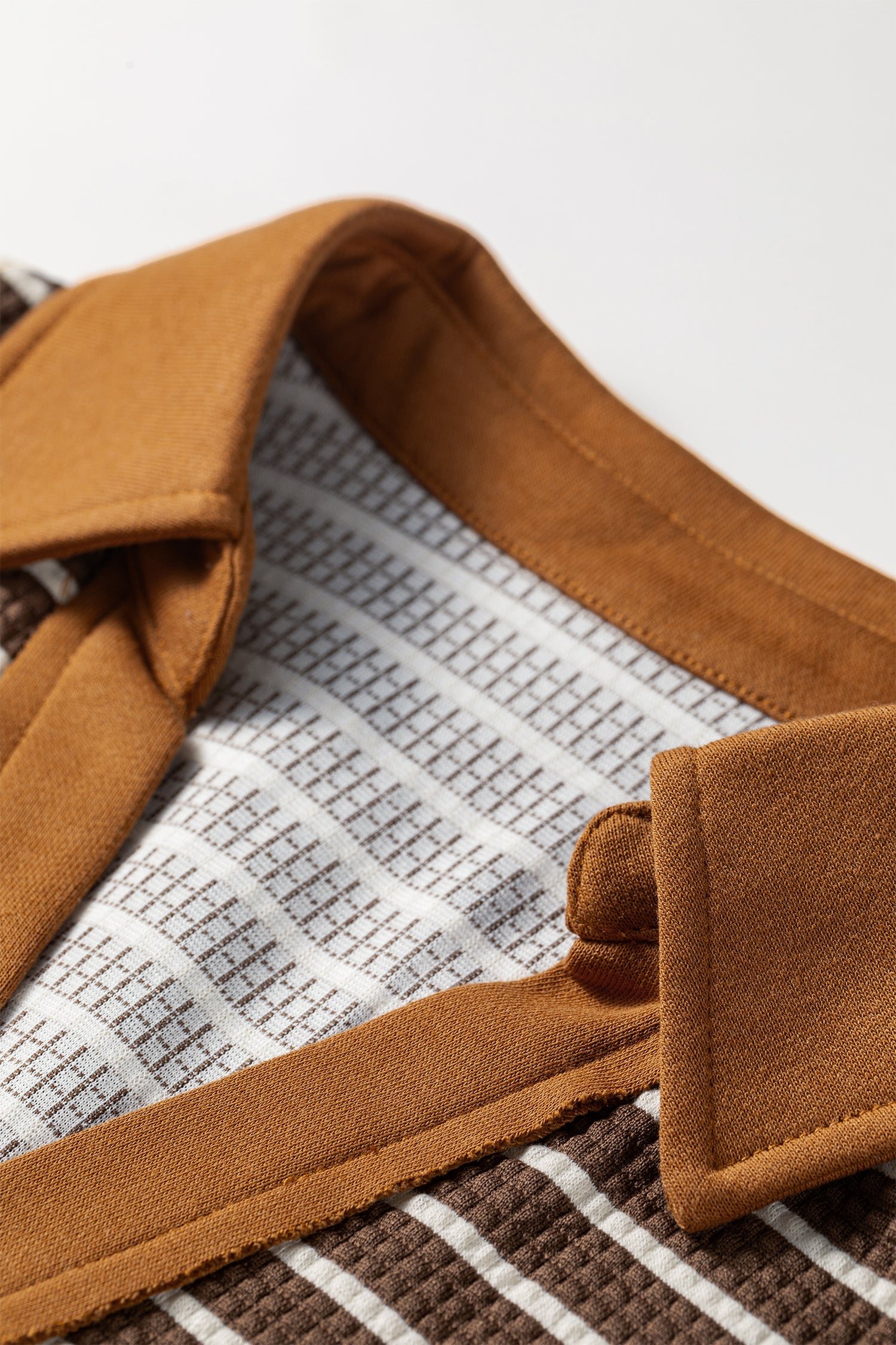 Cocoa Caramel and ivory striped colorblock pullover with a collared V-neckline, dropped shoulders, and long paneled sleeves.
