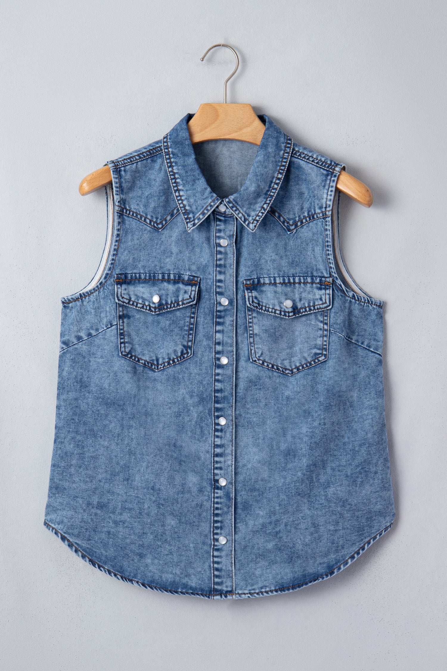 Women's Vintage Denim Wash Acid Wash Sleeveless Denim Button-Up Tank Top featuring a collared neckline, snap button front, western yoke, flap chest pockets, and curved hem.