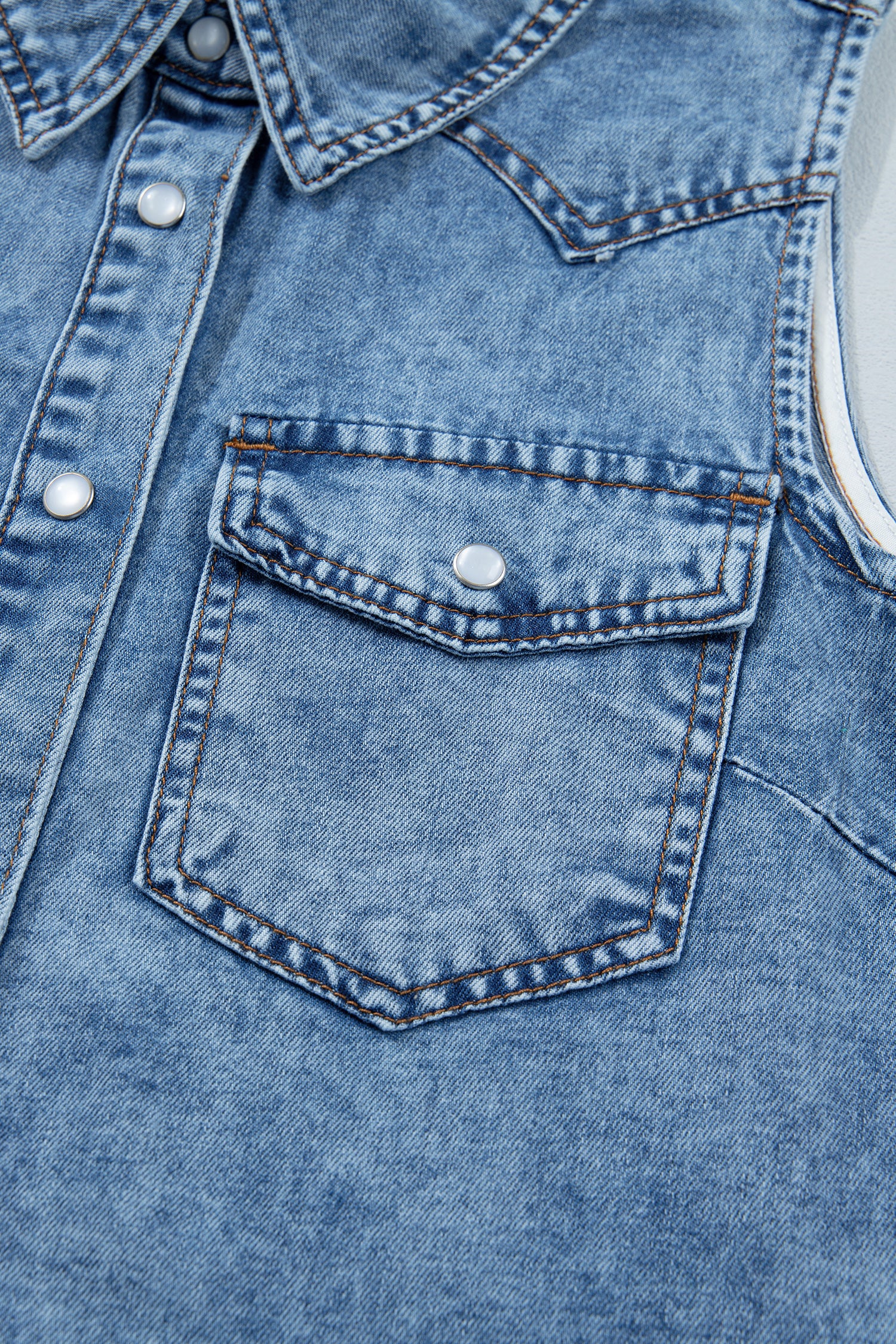 Women's Vintage Denim Wash Acid Wash Sleeveless Denim Button-Up Tank Top featuring a collared neckline, snap button front, western yoke, flap chest pockets, and curved hem.