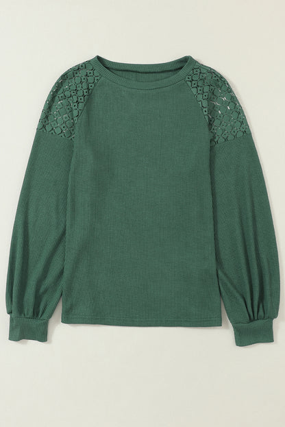 Forest green waffle knit long sleeve top with floral lace shoulder panels, crew neckline, relaxed fit, and balloon sleeves.