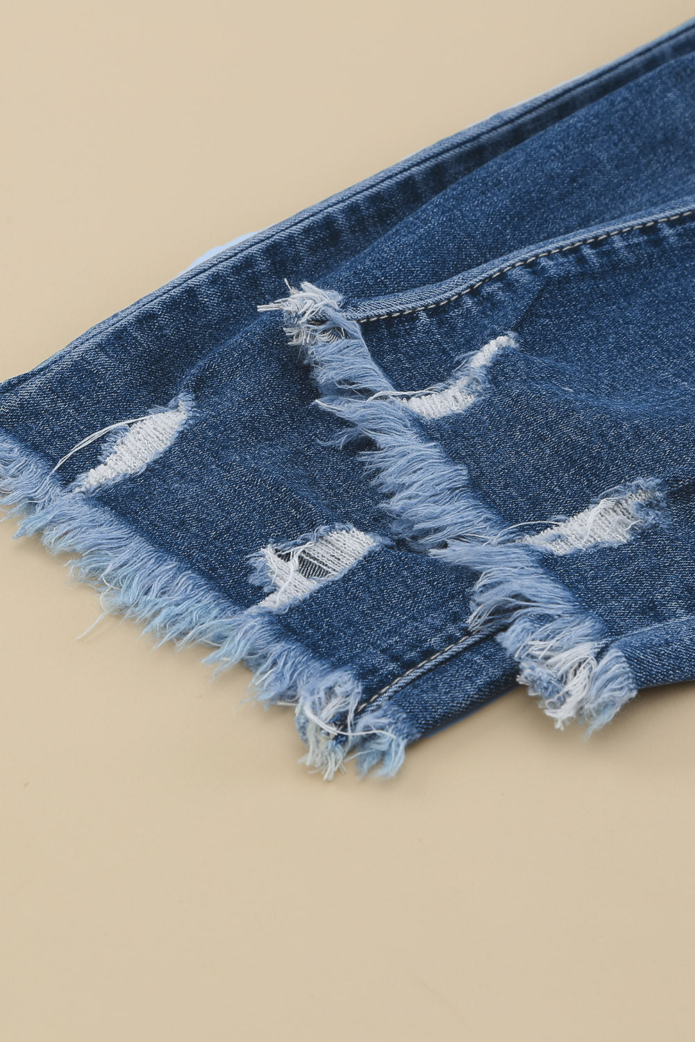 Medium wash blue distressed slim straight leg jeans with drawstring elastic waist and raw hem