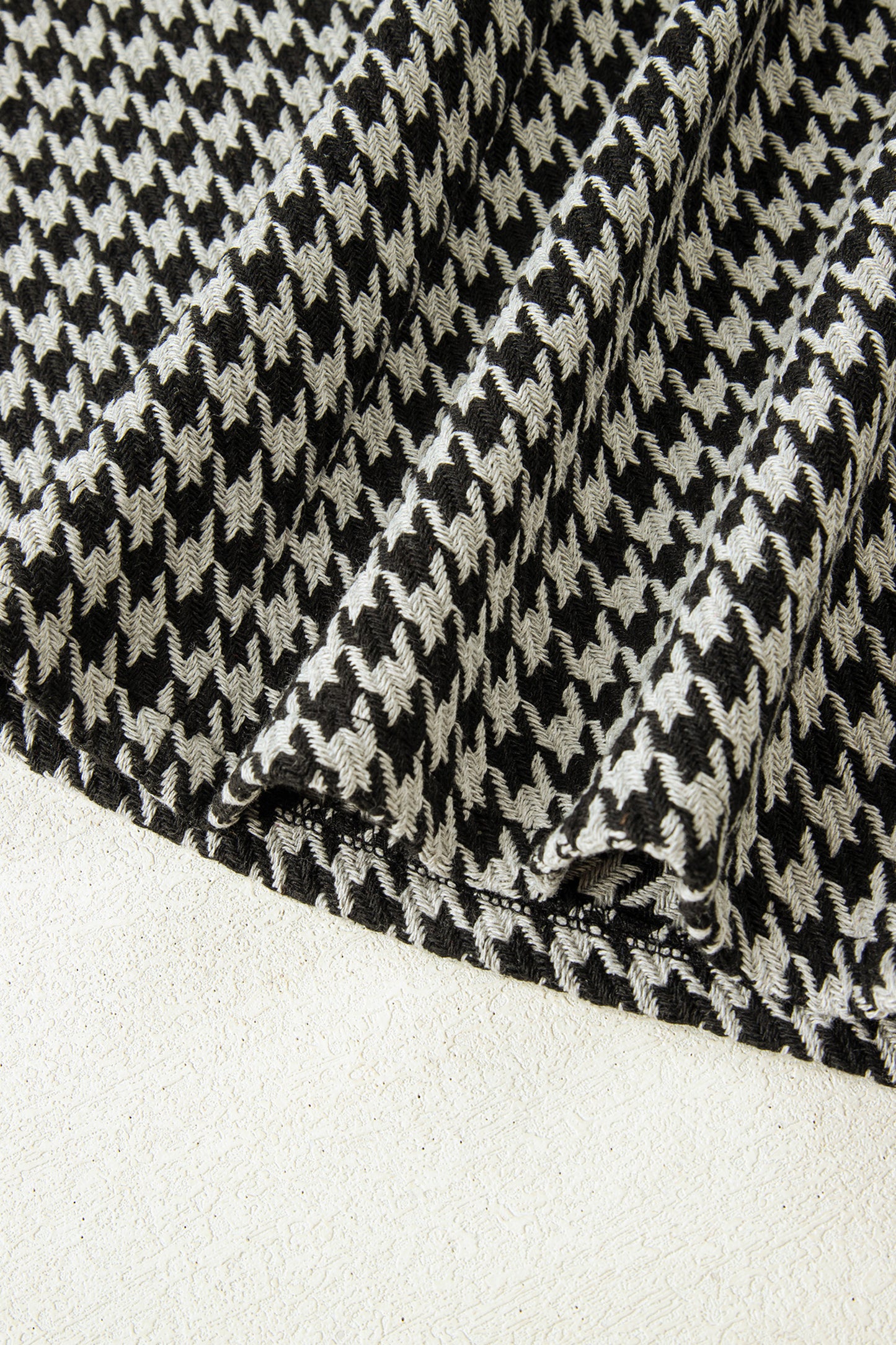 Black textured houndstooth jacquard sleeveless mini dress with V-neckline and A-line silhouette.