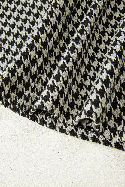 Black textured houndstooth jacquard sleeveless mini dress with V-neckline and A-line silhouette.