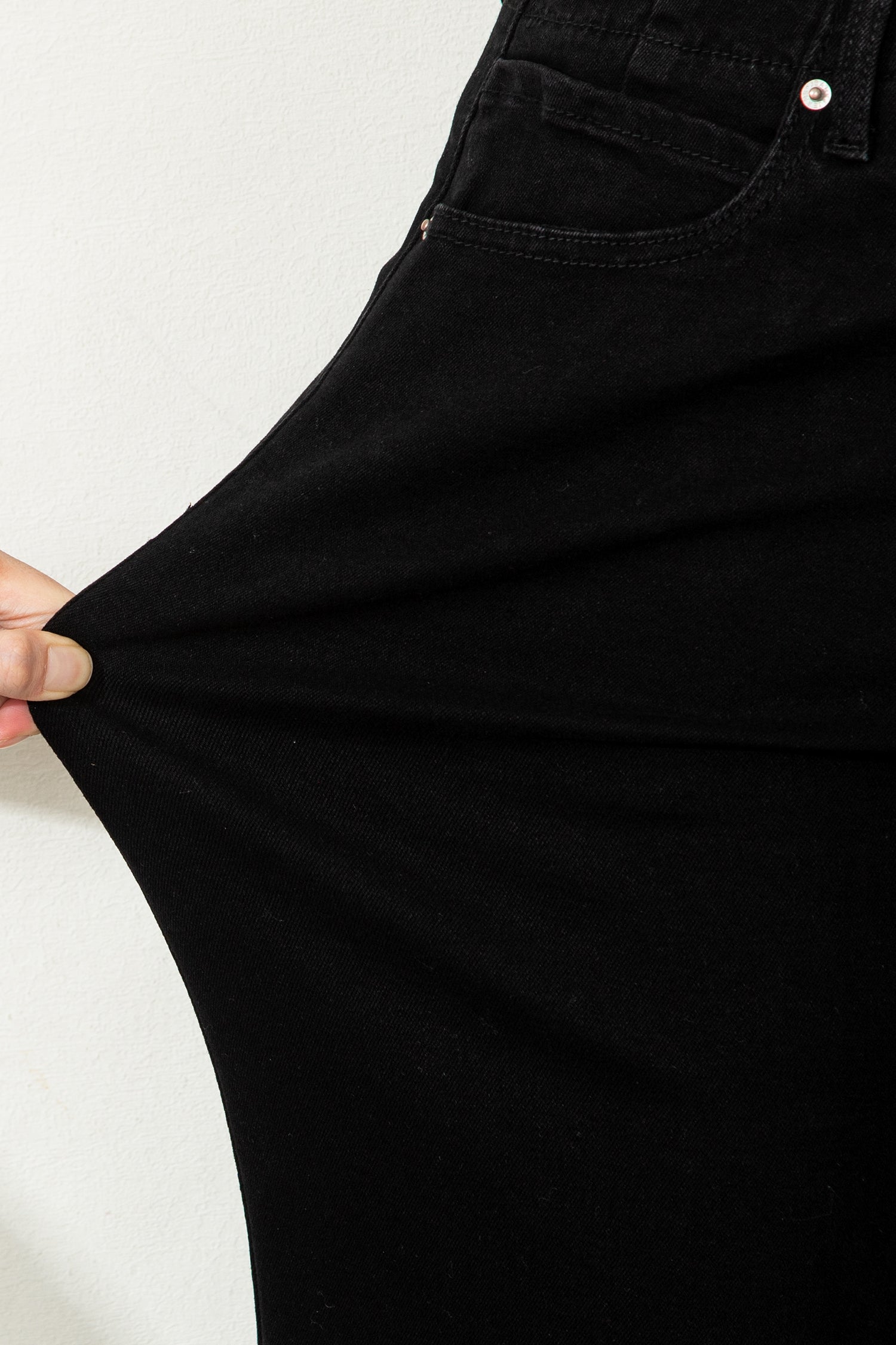 Black high rise wide leg jeans with double-button waistband, front pockets and cropped hem.