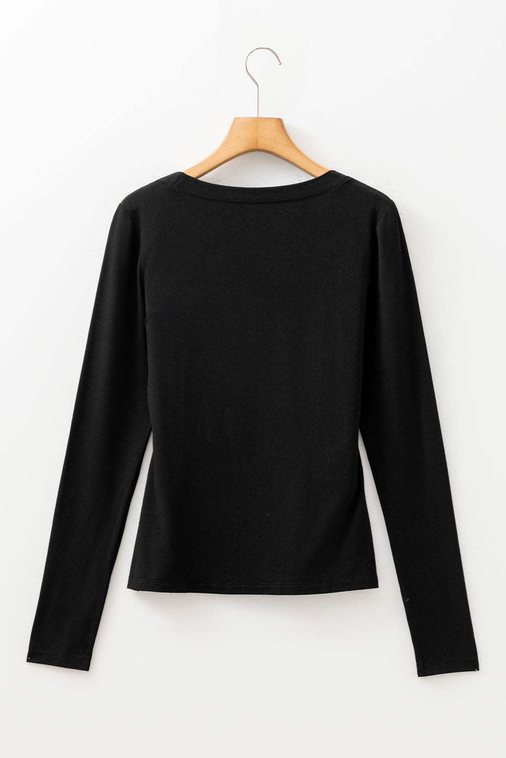 Woman wearing a Classic Black scoop neck long sleeve top with a soft casual fit and white pants.