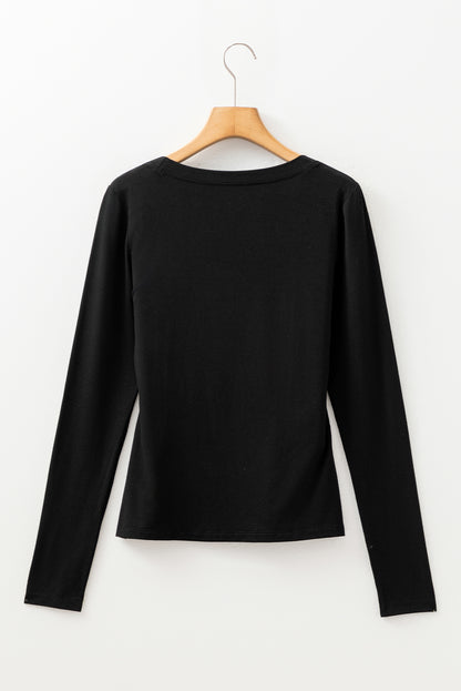 Woman wearing a Classic Black scoop neck long sleeve top with a soft casual fit and white pants.