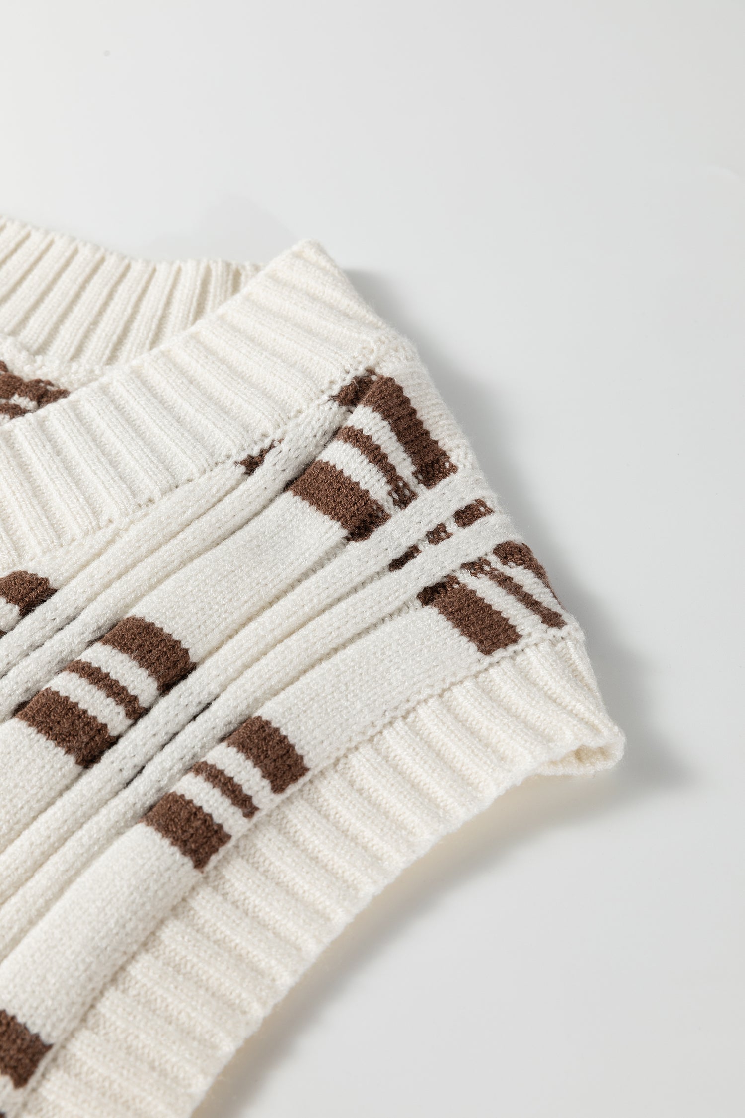 Oatmeal knit sweater vest with brown striped pattern, V-neckline, sleeveless design, and ribbed trim.