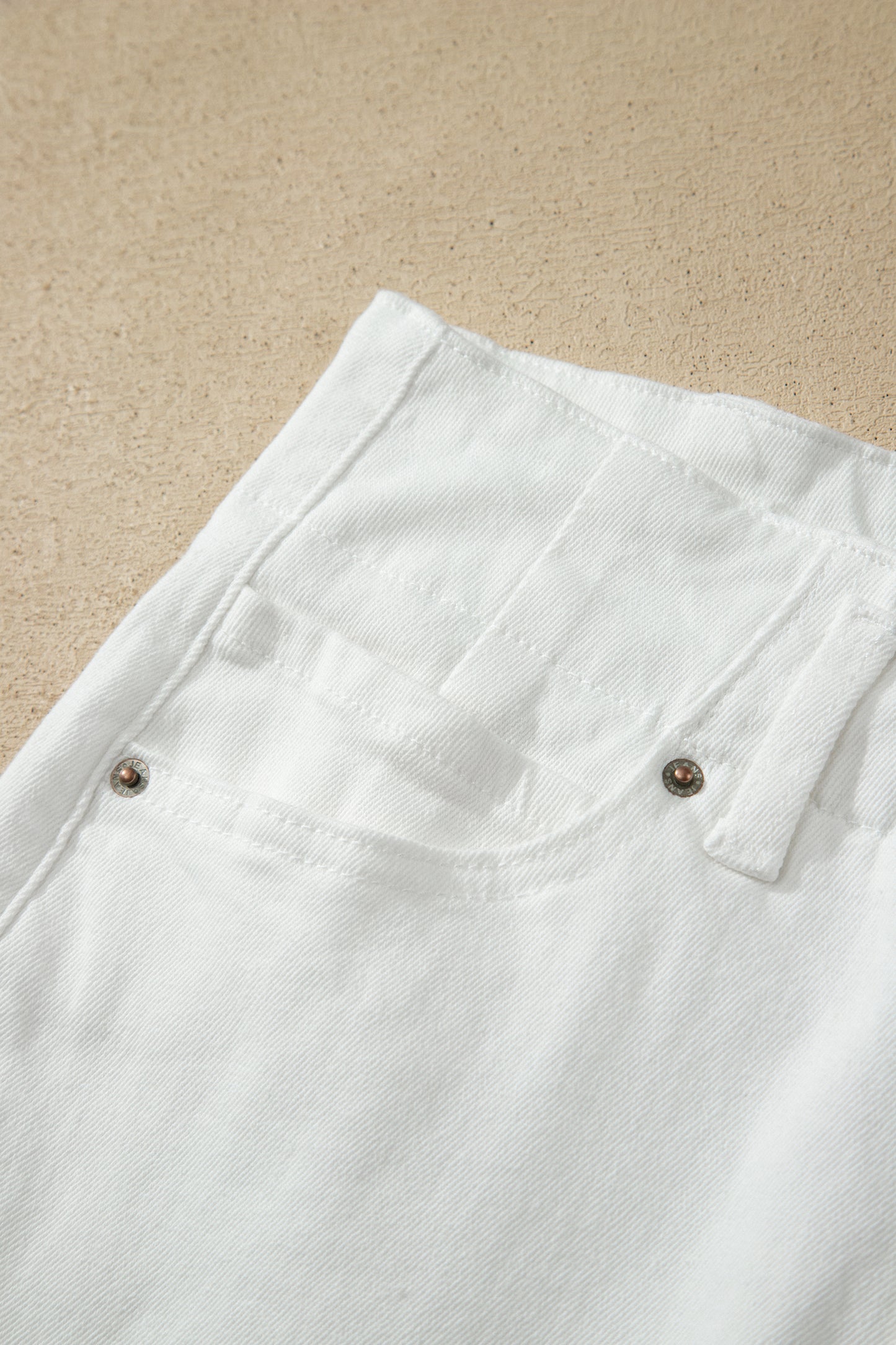White high rise wide leg jeans with double-button waistband, front pockets and cropped hem.
