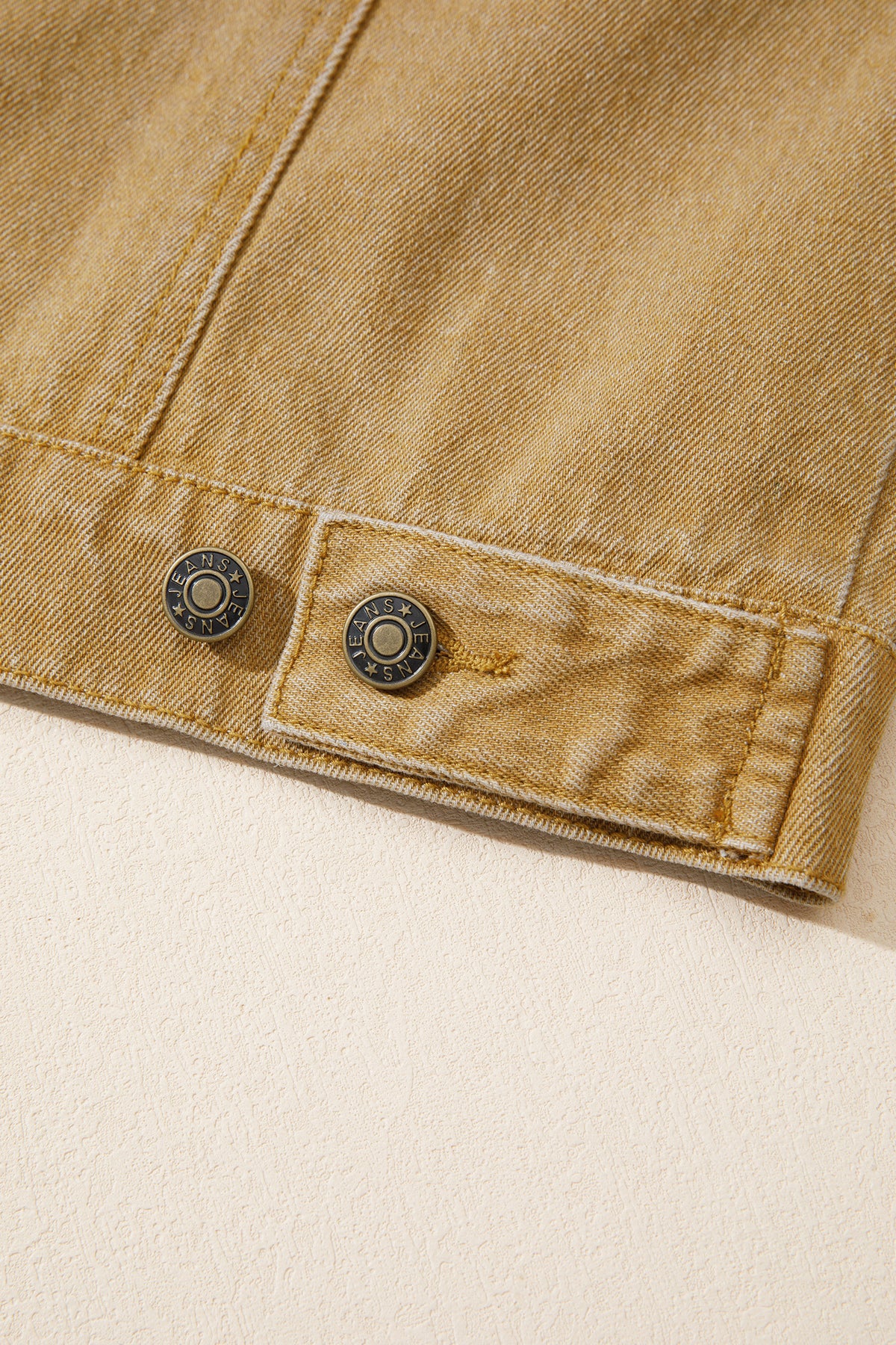 Tan women's denim jacket with metal button front, collared neckline, long sleeves, patch pockets, and relaxed fit.