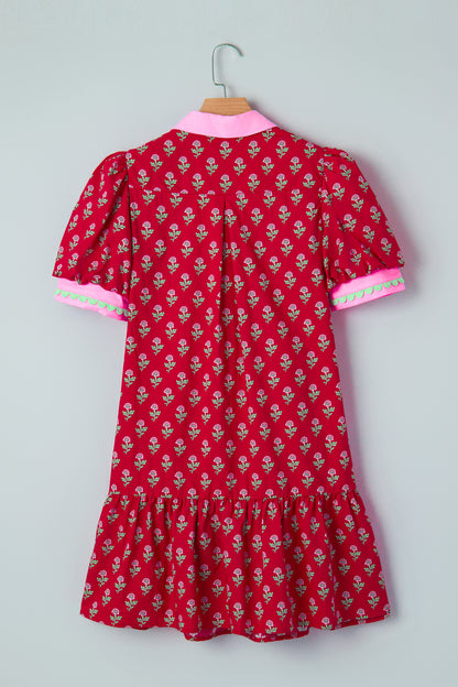 Red floral mini dress with pink collared neckline, mint scalloped trim, short puff sleeves, and a ruffled drop-waist hem