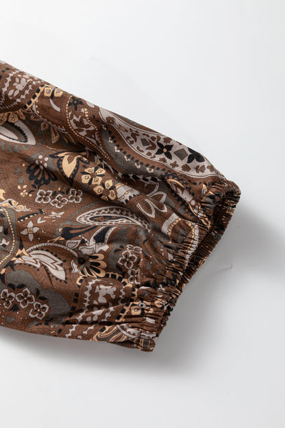 Mocha paisley babydoll mini dress with V-neckline, tie detail, long gathered sleeves, and relaxed tiered silhouette.