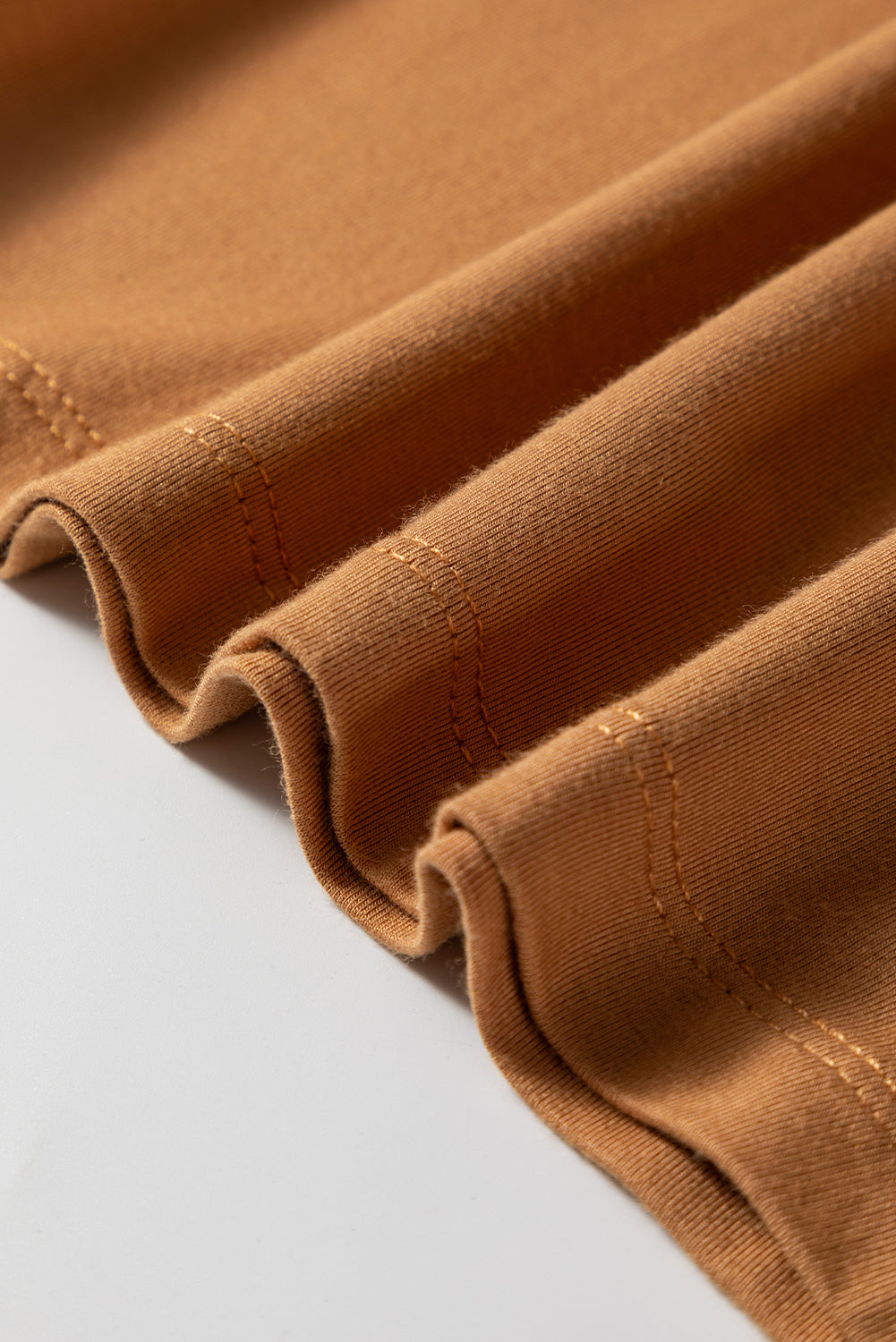 Woman wearing a Caramel Mocha scoop neck long sleeve top with a soft casual fit and white pants.