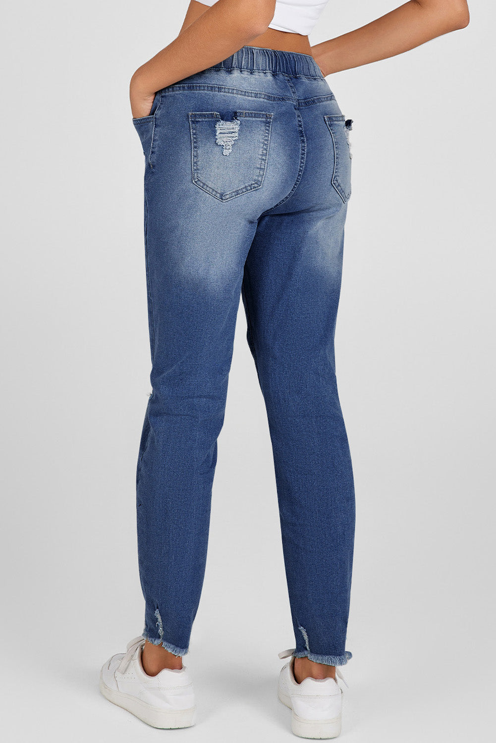 Medium wash blue distressed slim straight leg jeans with drawstring elastic waist and raw hem