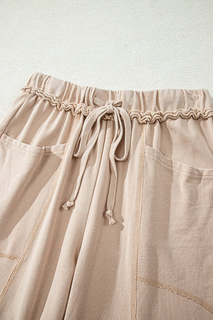 Sand washed cotton wide leg pants with drawstring waist, oversized patch pockets, and relaxed fit.
