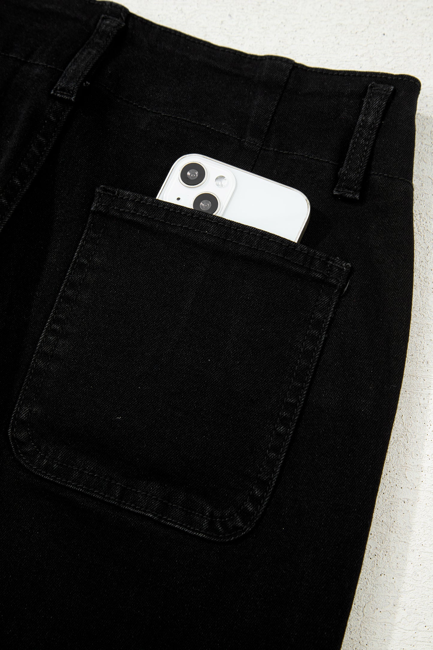 Black high rise wide leg jeans with double-button waistband, front pockets and cropped hem.