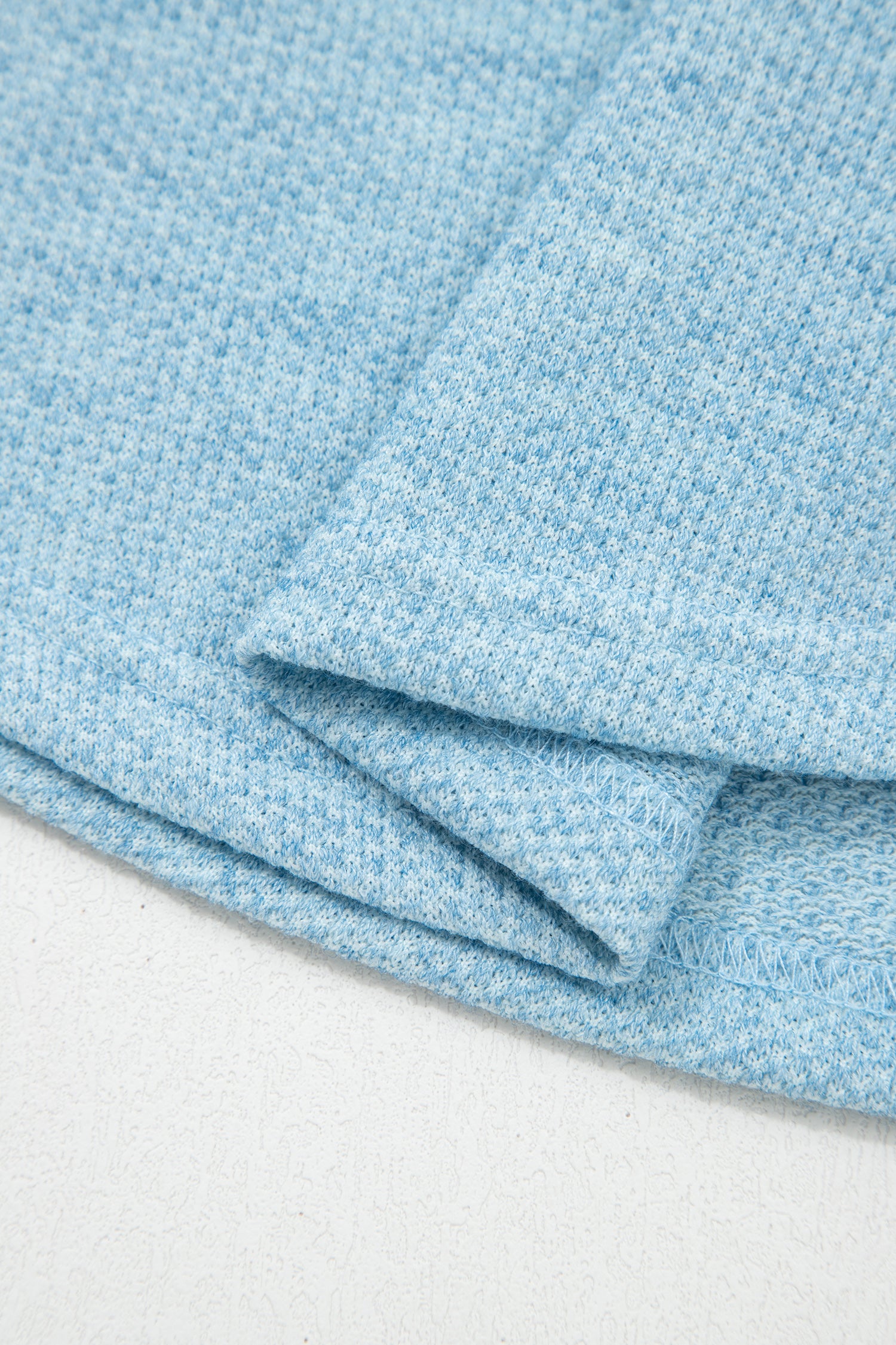 Powder Blue textured raglan long sleeve top with round neckline, relaxed fit, and curved hem
