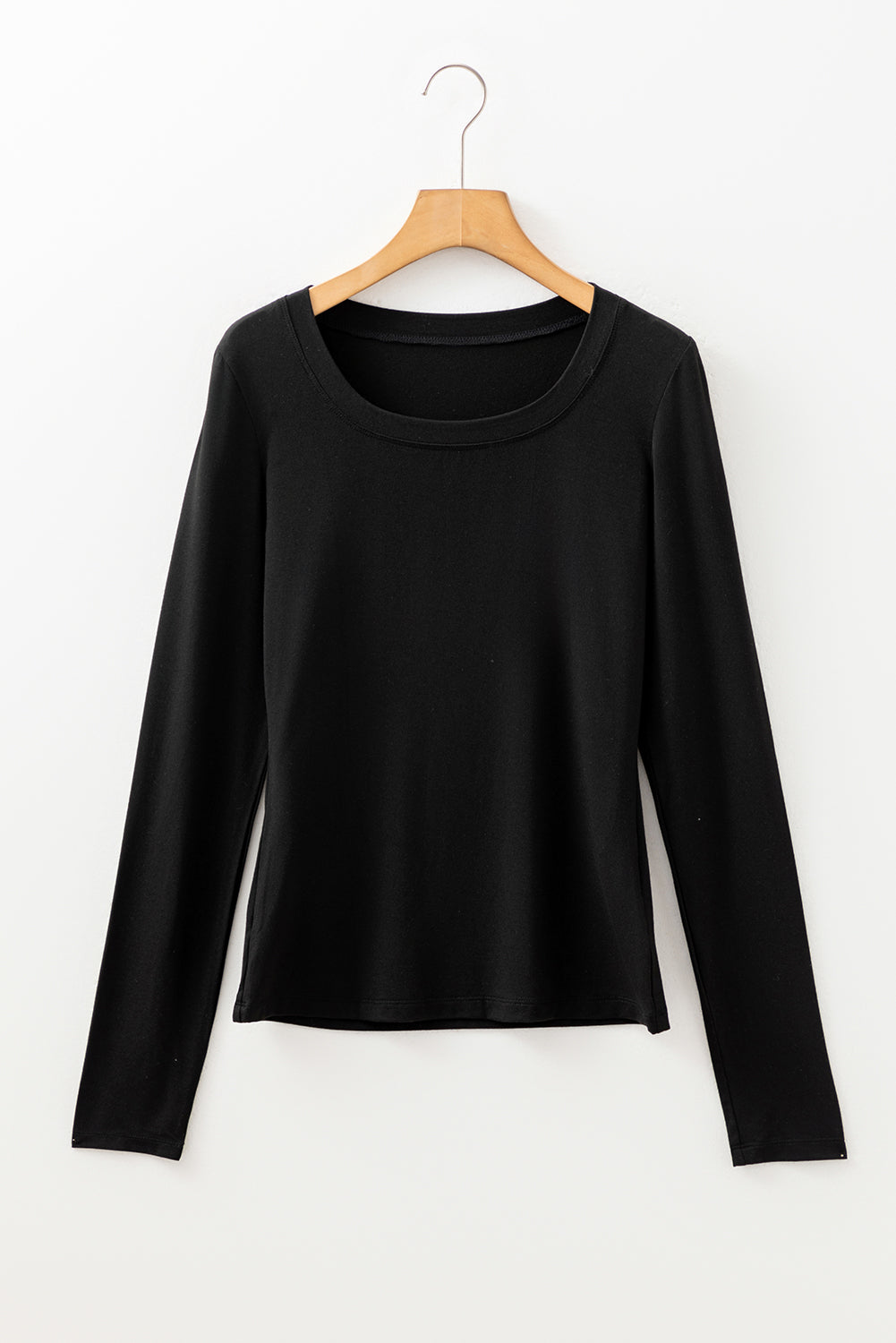 Woman wearing a Classic Black scoop neck long sleeve top with a soft casual fit and white pants.
